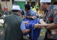 Doc.Dr. H. Dian Rachmat Yanuar, M.Si. sedang ikut mengangkat Sahrun (75) hidup sebatang kara (Foto Dokumentasi : MI)
