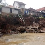 Doc. Curah hujan tinggi yang mengguyur wilayah hulu Sungai Cisande pada Senin (16/6/2025) pukul 17.00 WIB menyebabkan ambruknya Tembok Penahan Tanah (TPT) setinggi 4 meter dengan panjang 25 meter di Desa Bendungan, Kecamatan Lebakwangi, Kabupaten Kuningan. Bencana ini memicu abrasi tanah parah yang kini mengancam keselamatan lima rumah warga di bantaran sungai.